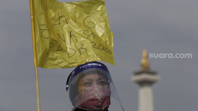 Sejumlah orang tua murid yang tergabung dalam Relawan PPDB DKI Jakarta membawa bendera kuning saat aksi unjuk rasa terkait sistem PPDB DKI Jakarta di depan Istana Negara, Jakarta Pusat, Jumat (3/7). [Suara.com/Angga Budhiyanto]