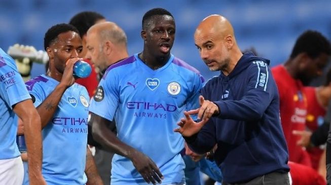 Manajer Manchester City Josep Guardiola memberikan arahan kepada pemainnya dalam pertandingan Liga Inggris kontra Liverpool di Etihad Stadium, Jumat (3/7/2020). [AFP]