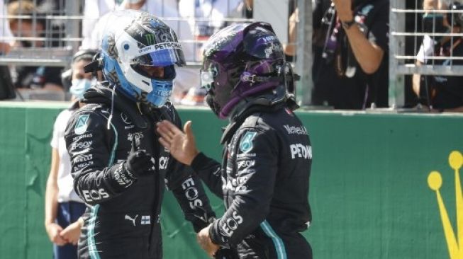 Pebalap Mercedes Lewis Hamilton (kanan) memberikan selamat kepada rekan setimnya, Valtteri Bottas setelah mencatat waktu tercepat saat sesi kualifikasi GP Austria. LEONHARD FOEGER / AFP