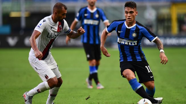 Pemain depan Inter Milan Lautaro Martinez (kanan) bersaing dengan bek Bologna Brasil Danilo selama pertandingan sepak bola Serie A Italia antara Inter Milan melawan Bologna di stadion Giuseppe-Meazza, Milan, Italia, Minggu (5/7). [MIGUEL MEDINA / AFP]