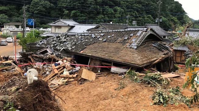 Penampakan rumah yang runtuh usai dihantam tanah longsor yang disebabkan oleh hujan lebat di Ashikita, Prefektur Kumamoto, Jepang,  pada 5 Juli 2020.  [STR / JIJI PRESS / AFP]