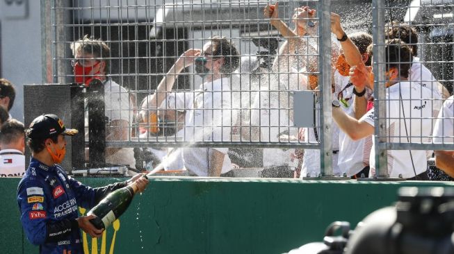 Pebalap McLaren Lando Norris (kiri) merayakan keberhasilan meraih podium bersama kru timnya di F1 GP Austria di Sirkuit Red Bull Ring, Minggu (6/7/2020). [AFP/Leonhard Foeger]