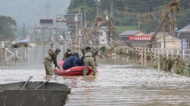 Petugas mengevakuasi korban banjir yang melanda Pulau, Kyushu, Jepang, Minggu (5/7/2020). [AFP]