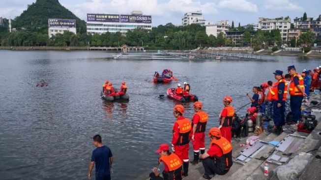 Petugas melakukan pencarian penumpan bus yang terjun ke waduk Hongshan di Anshun, provinsi Guizhou, Selasa (7/7/2020). Akibatnya, 21 orang meninggal dunia dan 16 lainnya mengalami luka. [AFP]