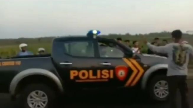 Santai Walau Mobil Aparat Melintas, Kerumunan Balap Liar Ini Bikin Salfok