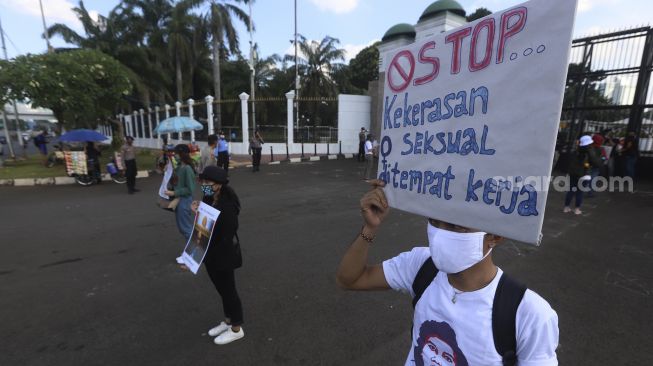 Massa yang tergabung dalam Gerak Perempuan membawa poster penolakan saat melakukan aksi unjuk rasa di depan gedung Dewan Perwakilan Rakyat Republik Indonesia (DPR RI), Jakarta, Selasa (7/7). [Suara.com/Angga Budhiyanto]