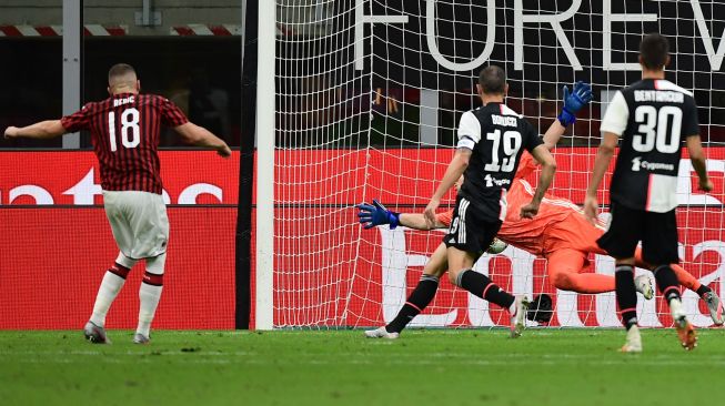 Pemain depan AC Milan Ante Rebic (kiri) menembak untuk mencetak gol ke-4 AC Milan, selama pertandingan sepak bola Serie A Italia AC Milan melawan Juventus di Stadion San Siro, Milan, Rabu (8/9) dini hari WIB. [Miguel MEDINA / AFP]