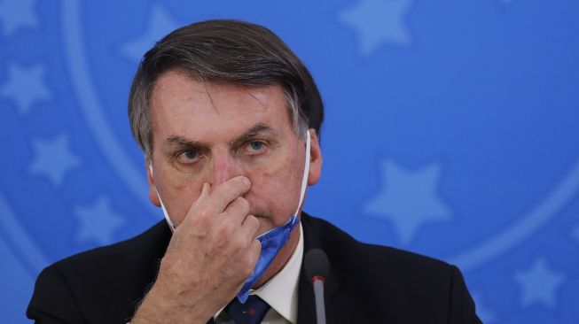 Presiden Brasil Jair Bolsonaro memegang hidung selama konferensi pers mengenai pandemi virus COVID-19, pandemi di Istana Planalto, Brasil. File foto ini diambil pada 23 Juni 2020. [Sergio LIMA / AFP]