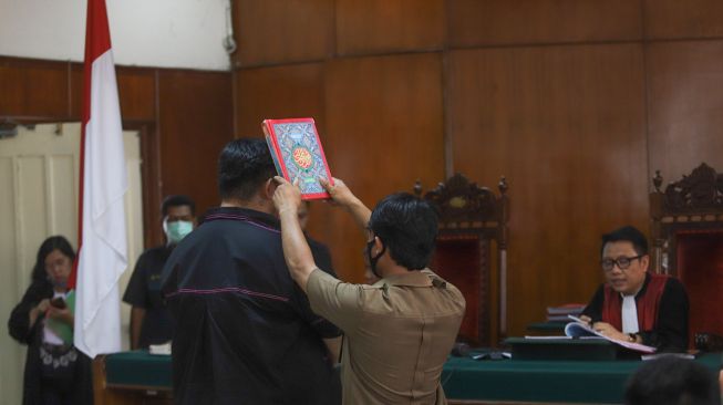 Desainer dan Presenter Ivan Gunawan disumpah dibawah Al-quran saat diperiksa sebagai saksi persidangan kasus klinik kecantikan ilegal di Pengadilan Negeri Jakarta Utara, Kamis (9/7). [Suara.com/Alfian Winanto]