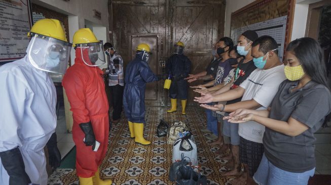 Petugas Rutan mengenakan Alat Pelindung Diri (APD) saat menerima tahanan baru dari Polresta Solo di Rutan Klas IA Solo, Jawa Tengah, Kamis (9/7). [ANTARA FOTO/Mohammad Ayudha]