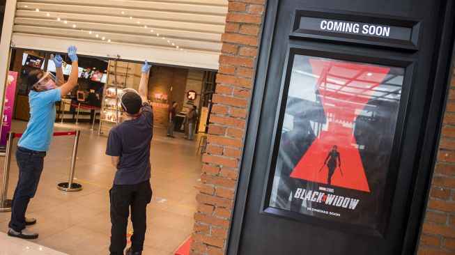 Pekerja menggunakan alat pelindung wajah saat menutup pintu seusai simulasi pembukaan dan peninjauan tempat hiburan bioskop CGV Cinemas di Bandung Electronic Center (BEC), Bandung, Jawa Barat, Kamis (9/7). [ANTARA FOTO/M Agung Rajasa]