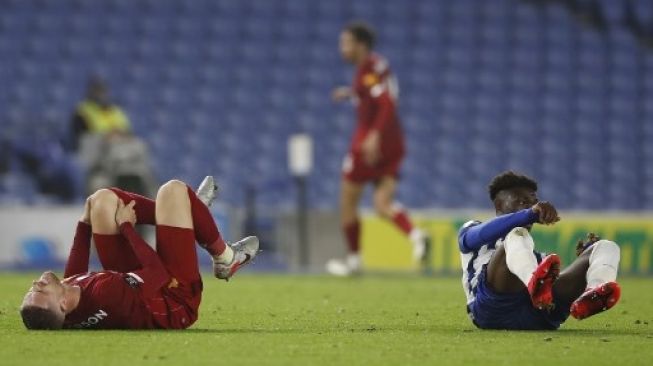 Jordan Henderson (kiri) mengalami cedera saat Liverpool berhadapan dengan Brighton and Hove Albion, pada pertandingan Liga Premier Inggris yang digelar 8 Juli 2020. [AFP]