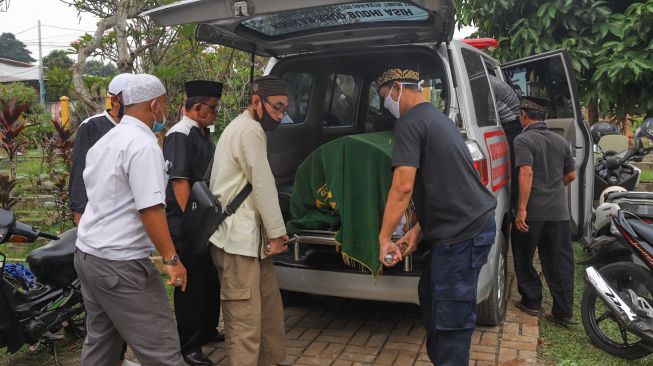 Jenazah Papa T Bob diturunkan dari ambulan di TPBU Jurang Mangu, Pondok Ranji, Tangerang Selatan, Jumat (10/7). [Suara.com/Alfian Winanto]
