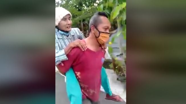 Salut! Ketua RT Jalan Kaki Gendong Lansia Antar ke Posko Bantuan Covid-19