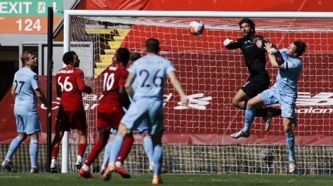 Penjaga gawang Liverpool Alisson Becker meninju bola dalam pertandingan pekan ke-35 Liga Inggris kontra Burnley yang berlangsung di Anfield, Sabtu (11/7/2020). [AFP]