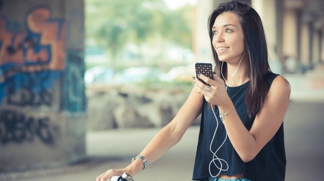 Ilustrasi mendengarkan musik sambil bersepeda. [Shutterstock]