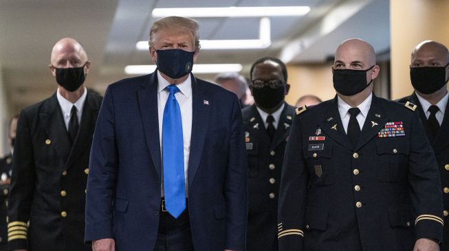 Presiden Amerika Serikat Donald Trump mengenakan masker kunjunganya ke Pusat Kesehatan Militer Nasional Walter Reed di kawasan Washington, Amerika Serikat.  [ALEX EDELMAN / AFP]