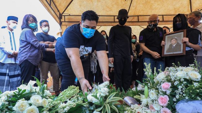 Desainer dan Presenter Ivan Gunawan menaruh bunga diatas pusara ayahnya, Bambang Cahyo Gunawan di TPU Kampung Kandang, Jagakarsa, Jakarta Selatan, Senin (13/7). [Suara.com/Alfian Winanto]