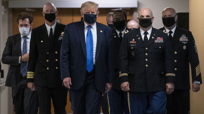 Presiden Amerika Serikat Donald Trump mengenakan masker kunjunganya ke Pusat Kesehatan Militer Nasional Walter Reed di kawasan Washington, Amerika Serikat.  [ALEX EDELMAN / AFP]