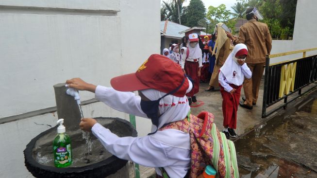 Sejumlah murid mencuci tangan sebelum masuk hari pertama sekolah di SDN 11 Marunggi Pariaman, Sumatera Barat, Senin (13/7/2020). [Foto/Antara]