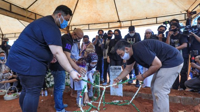 Ivan Gunawan menaruh bunga diatas pusara ayahnya, Bambang Cahyo Gunawan di TPU Kampung Kandang, Jagakarsa, Jakarta Selatan, Senin (13/7). [Suara.com/Alfian Winanto]