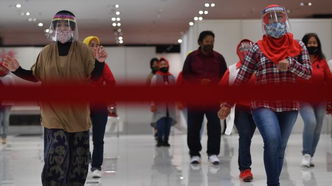 Sejumlah ibu melakukan senam lantai dengan menerapkan protokol kesehatan COVID-19 di salah satu pusat perbelanjaan di Surabaya, Jawa Timur, Selasa (14/7/2020).  [ANTARA FOTO/Zabur Karuru]