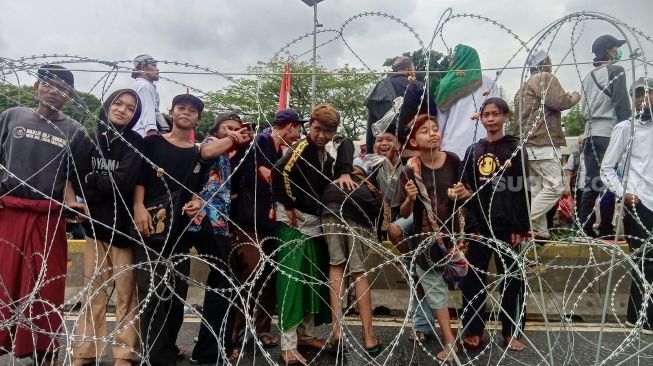 Sejumlah remaja tanggung terlihat bergabung dalam massa aksi yang menuntut agar adanya pembatalan pembahasan RUU Haluan Ideologi Pancasila (HIP) di depan Gedung DPR/MPR RI, Senayan, Jakarta, Kamis (16/7/2020). (Suara.com/Yosea Arga)