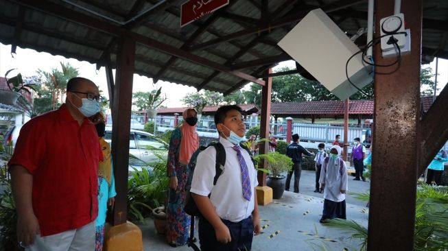 Siswa melakukan cek suhu tubuh sebelum memasuki sekolah di Bandar Baru Bangi, Selangor, Malaysia pada 15 Juli 2020. [Foto/ Anadolu Agency]