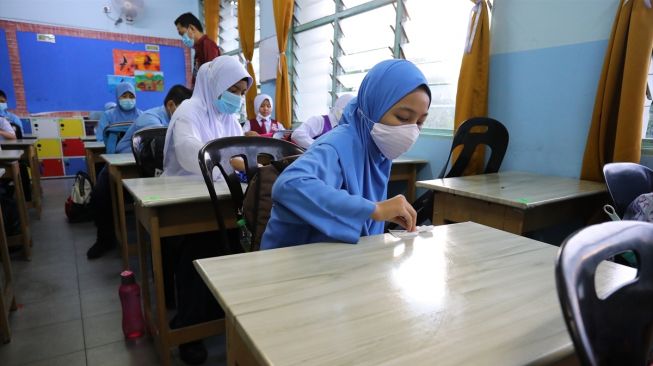 Siswa membersihkan meja dengan handsanitizer sebelum mulai mengajar di Bandar Baru Bangi, Selangor, Malaysia pada 15 Juli 2020. [Foto/ Anadolu Agency]
