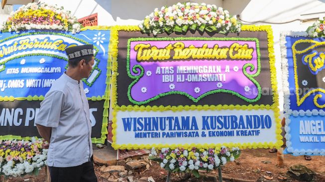 Warga melihat karangan bunga untuk komedian Omaswati di rumah duka di kawasan Cimanggis, Depok, Jawa Barat, Jumat (17/7).[Suara.com/Alfian Winanto]