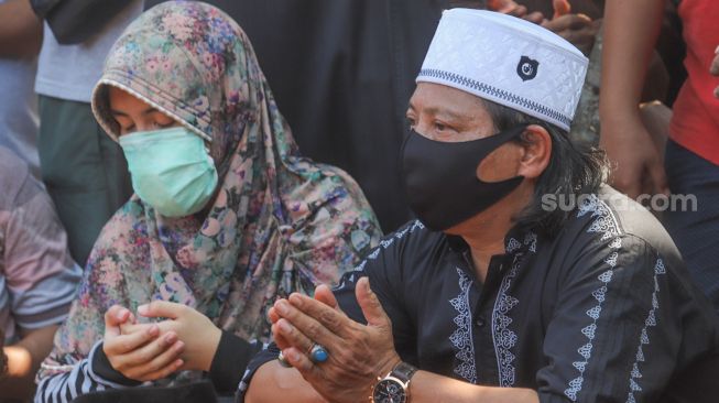 Wajah tegar Mastur, adik dari komedian Omaswati saat prosesi pemakaman kakaknya di TPU Cisalak, Cimanggis, Depok, Jawa Barat, Jumat (17/7). [Suara.com/Alfian Winanto]