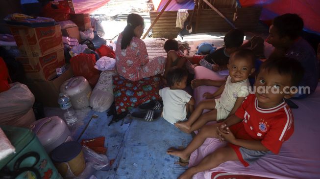 Warga Kampung Muka beraktivitas di tenda darurat yang didirikan secara mandiri setelah penggusuran pada 15 Juli 2020 lalu di Kawasan Stasiun Kampung Bandan, Jakarta, Jumat (17/7/2020). [Suara.com/Angga Budhiyanto]