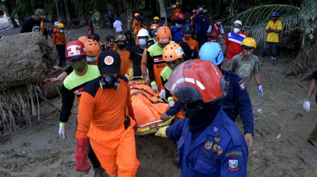 Tim SAR gabungan mengangkat kantong jenazah korban banjir bandang di Desa Radda, Kabupaten Luwu Utara, Sulawesi Selatan, Sabtu (18/7/2020).  [ANTARA FOTO/Abriawan Abhe]
