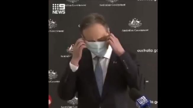 Menteri kesehatan Australia kesulitan mengenakan masker.[Twitter/@harrynathan_]