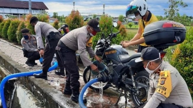 Petugas kepolisian Polsek Kuala, Polres Nagan Raya, Aceh melakukan simulasi pemadaman karhutla menggunakan sepeda motor dinas Babinkamtibmas modifikasi yang dipusatkan di Alun-Alun Suka Makmue, Nagan Raya, Sabtu (18/7/2020) [FOTO ANTARA/HO-Polsek Kuala Polres Nagan Raya]