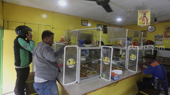 Suasana di warteg yang menerapkan protokol kesehatan di kawasan Cilandak Timur, Jakarta Selatan, Senin (20/7/2020). [Suara.com/Angga Budhiyanto]