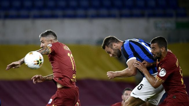 Bek Inter Milan Stefan de Vrij (C) menyundul bola dan mencetak gol selama pertandingan sepak bola Serie A Italia antara AS Roma melawan Inter Milan di Stadion Olimpico, Roma, Italia, Senin (20/7) dini hari WIB.
[Filippo MONTEFORTE / AFP]