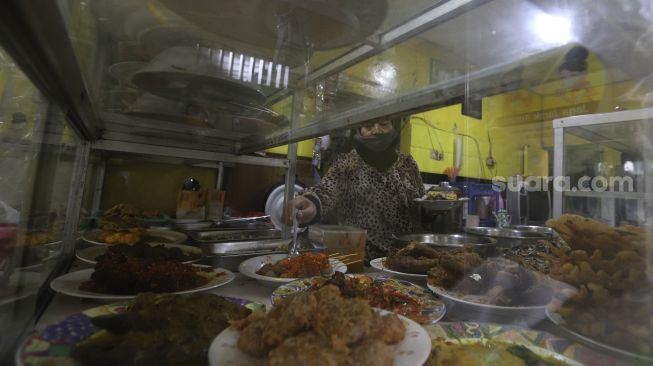 Aktivitas di warteg yang menerapkan protokol kesehatan di kawasan Cilandak Timur, Jakarta Selatan, Senin (20/7/2020). [Suara.com/Angga Budhiyanto]