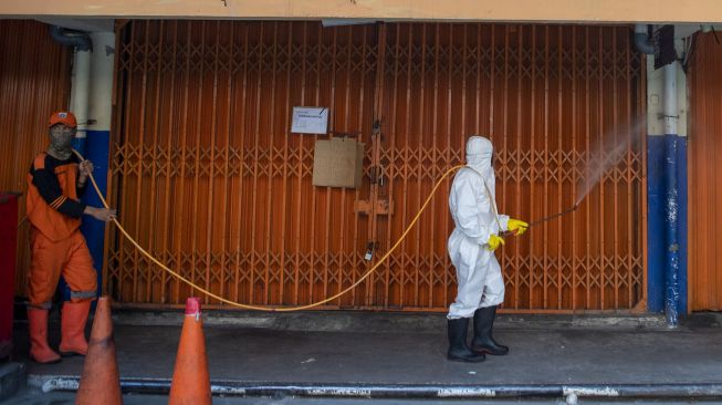 Petugas kebersihan menyemprotkan cairan disinfektan di area Pasar Asem Reges, Jakarta Barat, Selasa (21/7/2020).   [ANTARA FOTO/Nova Wahyudi]