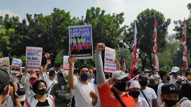 Sejumlah poster yang dibawa pekerja diskotek, terapis pijat dan pegawai karaoke saat bedemo di depan gedung Balai Kota Jakarta. (Suara.com/Bagaskara).