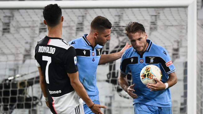 Pemain depan Lazio Ciro Immobile (kanan) merayakan golnya dengan rekan setimnya selama pertandingan sepak bola Serie A Italia antara Juventus melawan Lazio di Stadion Allianz, di Turin, Italia, Selasa (21/7) dini hari WIB. Marco BERTORELLO / AFP
