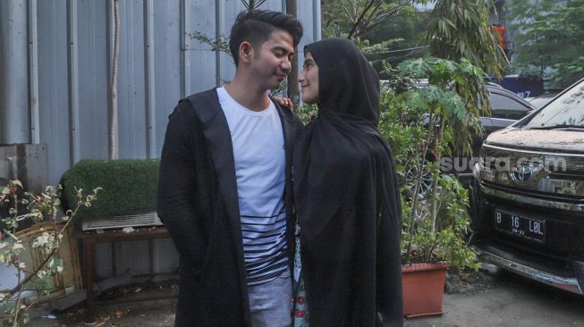 Rizki D'Academy dan istrinya Nadya Mustika berpose mesra didepan kamera saat ditemui di Kawasan Tandean, Jakarta Selatan, Selasa (21/7). [Suara.com/Alfian Winanto]