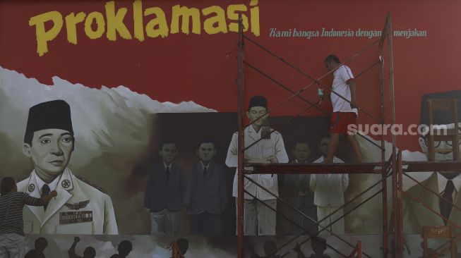 Pekerja menyelesaikan mural bertemakan Proklamasi di Sekolah Dasar Negeri (SDN) Pondok Aren 02, Tangerang Selatan, Banten, Rabu (22/7/2020). [Suara.com/Angga Budhiyanto]