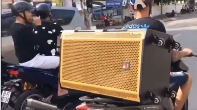 Aksi pemotor melakukan aksi karaoke di jalanan menggunakan motor (Facebook)