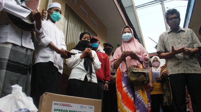 Pasien COVID-19 yang dinyatakan sembuh, Hartoyo (kanan) dan Sukati (kedua kanan) berdoa bersama warga yang menyambut di depan rumahnya di Kiduldalem, Malang, Jawa Timur, Rabu (22/7/2020).  [ANTARA FOTO/Ari Bowo Sucipto]