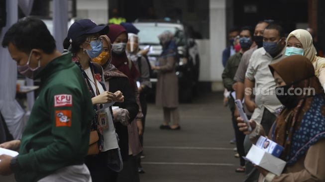 Sejumlah pemilih mengantre untuk mencoblos saat simulasi pemungutan suara Pilkada Serentak 2020 di Kantor Komisi Pemilihan Umum (KPU) Republik Indonesia, Jakarta, Rabu (22/72020). [Suara.com/Angga Budhiyanto]