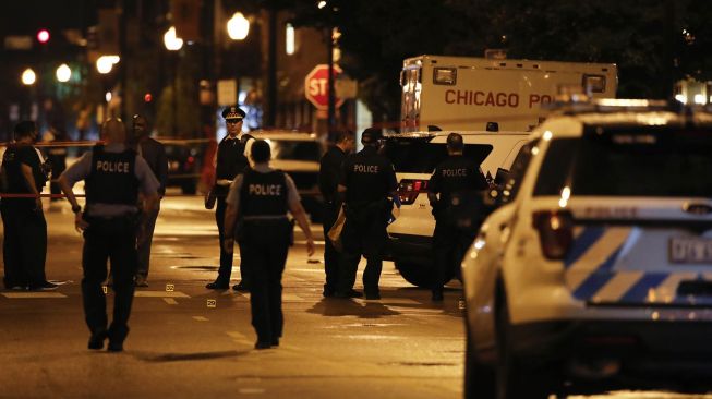 Polisi Chicago menyelidiki lokasi penembakan di Chicago, Illinois, Amerika Serikat,  Selasa (21/7). [KAMIL KRZACZYNSKI / AFP]