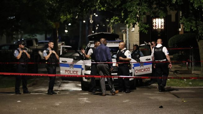 Petugas Kepolisian Chicago menyelidiki lokasi penembakan di Chicago, Illinois, Amerika Serikat,  Selasa (21/7).  Baku tembak terjadi di sebuah acara pemakaman di Chicago, AS pada Selasa malam (21/7).  [KAMIL KRZACZYNSKI / AFP]