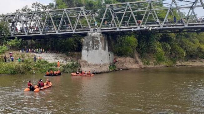 Sejumlah sukarelawan mencari jasad Purwati yang diduga bunuh diri di Sungai Bengawan Ngujur di perbatasan Kabupaten Madiun dan Kabupaten Magetan, Rabu (22/7/2020). [Foto: Solopos.com]