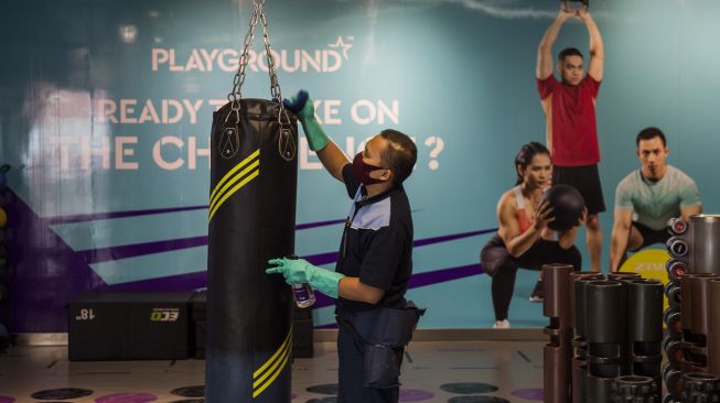 Petugas membersihkan alat bantu olahraga dan kebugaran saat simulasi pembukaan dan peninjauan tempat kebugaran di Celebrity Fitness, Bandung, Jawa Barat, Kamis (23/7/2020).  [ANTARA FOTO/M Agung Rajasa]